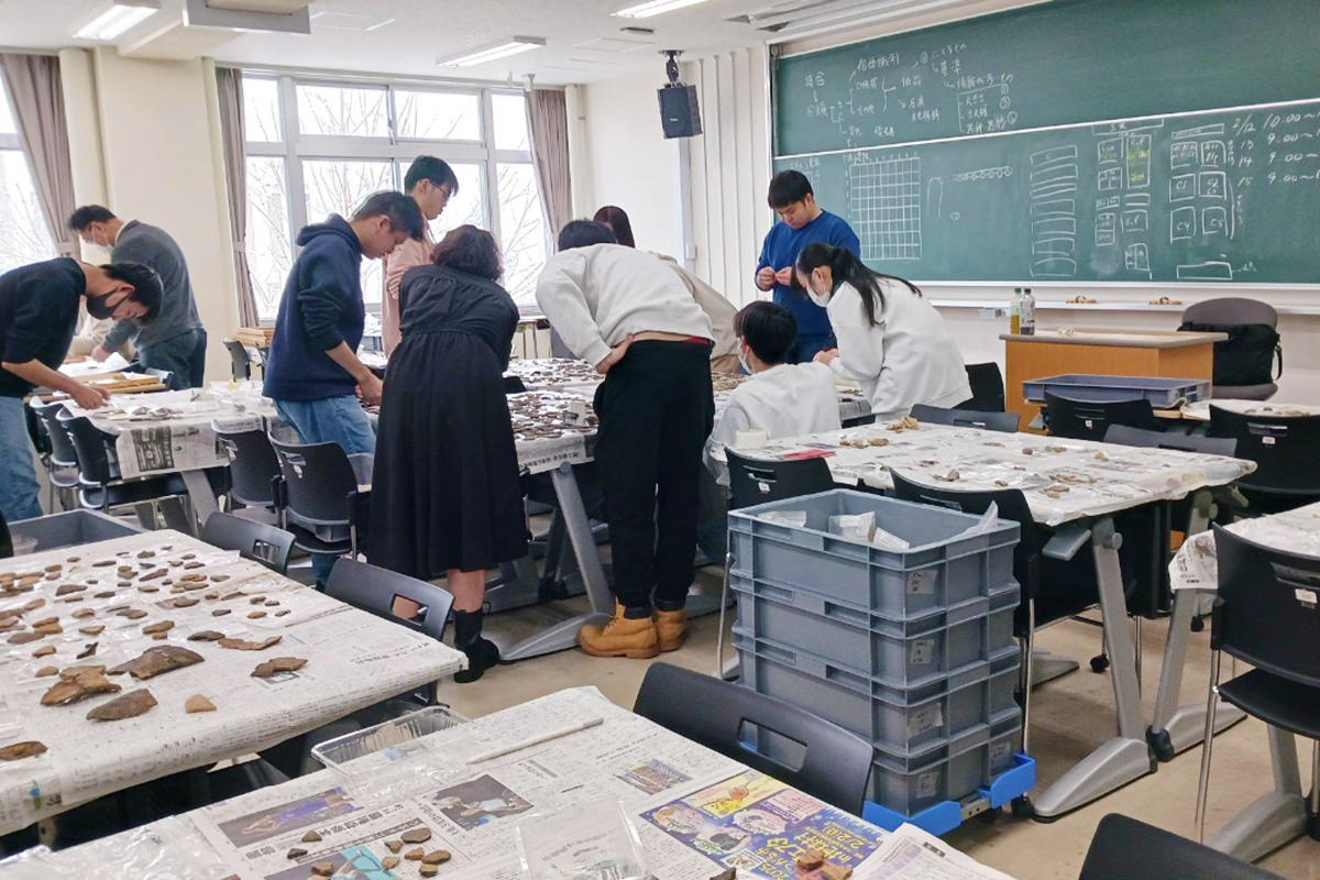 発掘調査で見つかった遺物を集めて並べ、分析する様子